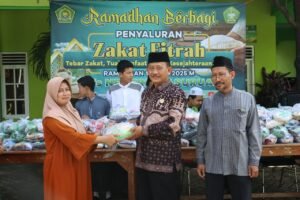 Kepala Madrasah menyerahkan Zakat Fitrah kepada warga sekitar